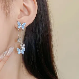 Close-up detail of silver needle butterfly drop earrings with crystal rhinestones