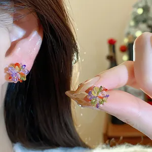 Detailed close-up showing colorful dopamine crystal flower stud earrings worn on ear.