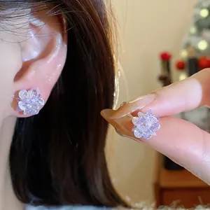 Close-up of lavender crystal flower stud earrings showing intricate faceted details.