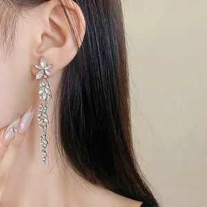 Exquisite silver needle crystal flower tassel earrings worn on ear for formal elegance