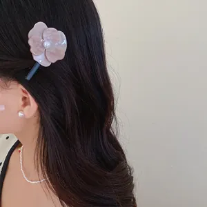 Elegant pink flower duckbill hair clip with pearl center detail shown on a model