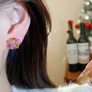 Close-up of colorful crystal flower stud earrings on ear for a sweet, vibrant aesthetic