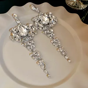 Macro detail of elegant silver water-drop tassel earrings with shimmering rhinestones