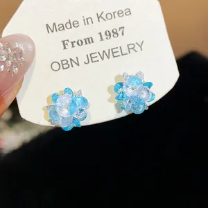 Close-up detail of blue and clear crystal flower stud earrings on display card