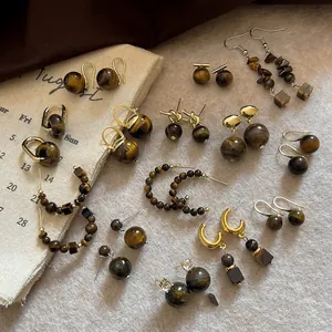 Close-up detail of various Maillard style retro tiger eye stone earrings collection