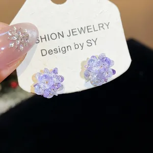Detail view of sparkling light purple crystal flower stud earrings on display card.