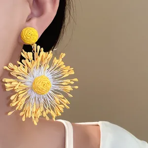 Detailed view of large hand-woven yellow sunflower earring with intricate petal texture