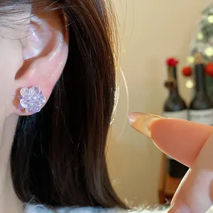 Detailed view of crystal flower stud earrings worn on the earlobe