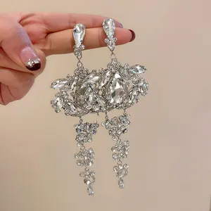 Detail shot of sparkling teardrop tassel earrings with silver needles and clear rhinestones