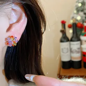 Detailed shot of vibrant colorful crystal flower stud earrings worn on a model's ear