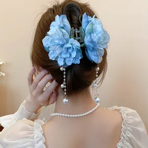 Detailed view of a light blue fabric flower hair claw with elegant pearl tassels.