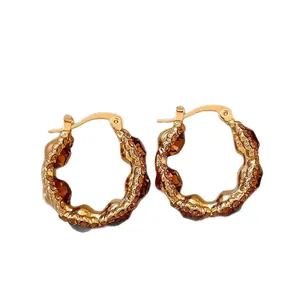 Elegant gold-plated hoop earrings with brown crystal accents and minimalist wave texture