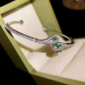 Vista detallada de un brazalete de serpiente plateado con circonitas blancas brillantes.