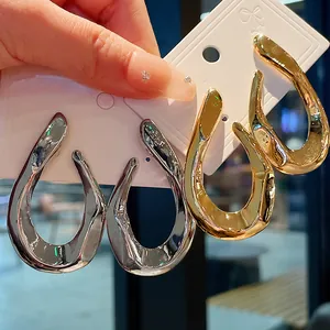 Detailed macro view of shiny twisted metal hoop earrings on a white jewelry card