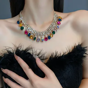 Detail view of a glamorous colorful geometric crystal necklace worn by a female model.