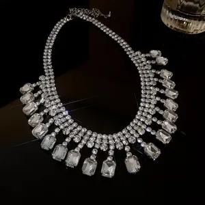 Close-up detail of a glamorous rhinestone necklace featuring large emerald-cut crystal stones.