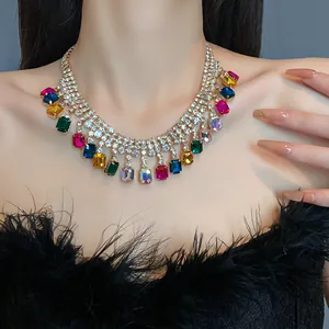 Close-up detail of a colorful rectangular gemstone and rhinestone necklace worn by a model