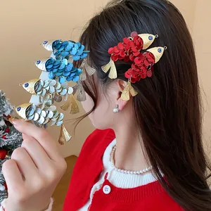 Detailed view of vintage shell fish-shaped hair clips in vibrant red and blue colors