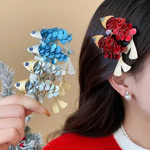 Detailed view of red and blue fish hair clips worn by a model for a festive look.