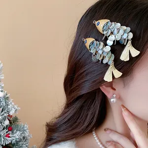 Close-up of unique vintage shell fish-shaped hair clip worn on model's long wavy hair