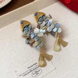 Close-up of vintage fish hair clips with shimmering shell scales and golden fins.