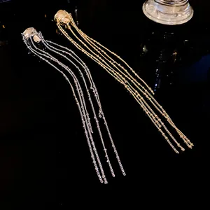 Close-up of gold and silver irregular geometric ear cuffs with long tassel chains
