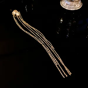 Elegant gold geometric ear cuff featuring multiple long hanging tassel chains detail view