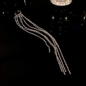 Detailed shot of irregular geometric silver ear cuff with long multi-strand chain tassels