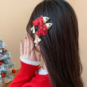 Detailed view of a vintage-style fish hair clip with red sequins on long dark hair