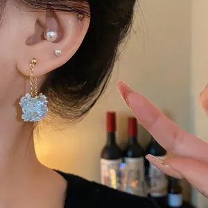 Gros plan de boucles d'oreilles vintage en perles et fleurs avec détails de grappes