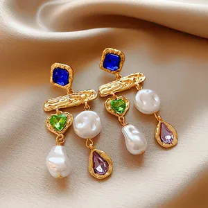 Primo piano di orecchini di perle vintage stile francese con cristalli colorati.