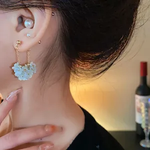 Gros plan détaillé montrant des boucles d'oreilles vintage à fleurs de perles sur un mannequin