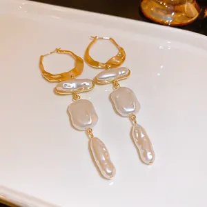 Dettaglio di orecchini pendenti con perle barocche vintage francesi e cerchi dorati
