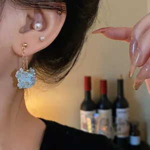 Vue détaillée d'élégantes boucles d'oreilles en forme de fleurs blanches avec des perles