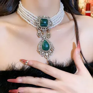 Close-up of vintage multi-strand pearl choker with emerald green gemstone pendant