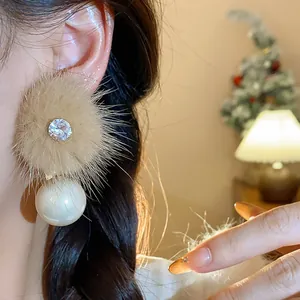Dettaglio di eleganti orecchini in peluche con zircone scintillante e perla classica