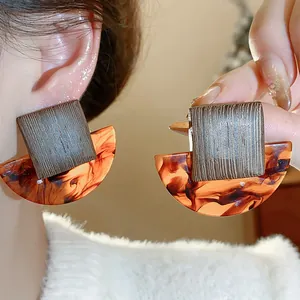 Detailed macro view showing the wood texture and amber resin patterns of these earrings