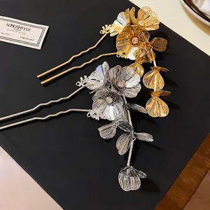 Elegant gold and silver floral metal hairpins with rhinestone tassels on a black background.