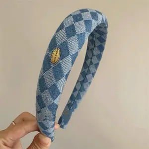 Close-up of retro blue checkered padded headband with golden MAKE A WISH tag