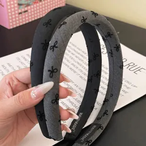 Detail shot of black and grey vintage bow headbands with handmade labels and patterns