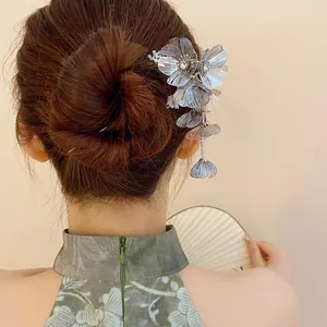 Elegant silver flower hair stick with sparkling rhinestones and tassels worn on a bun