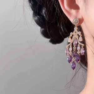 Détail de boucles d'oreilles vintage dorées 18 carats avec zircons marquise violets