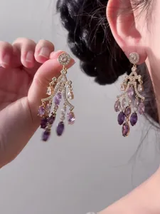 Détail des boucles d'oreilles lustre de style palais vintage avec des zircons violets