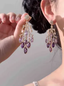 Vue détaillée d'élégantes boucles d'oreilles chandelier en zircon violet style palais