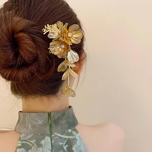Elegant gold floral hair pin with sparkling rhinestones and long metal tassels detail