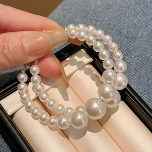 Elegant vintage oversized hoop earrings with graduated white pearls and silver needles design