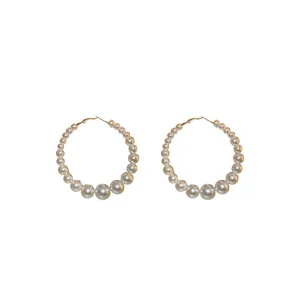 Elegant oversized hoop earrings featuring graduated white pearls on a polished gold-tone metal band