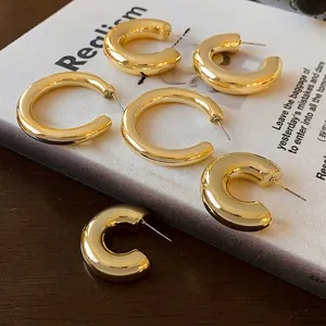 Minimalist gold C-shaped hoop earrings in thick and thin styles for a retro fashion look