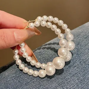 Detail view of elegant irregular pearl hoop earrings with gradient pearl sizes