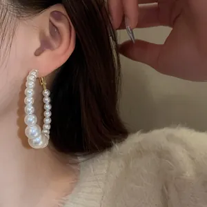 Elegant pearl hoop earrings with varying pearl sizes for a chic French retro look